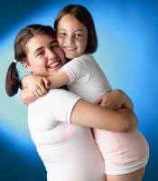 duas meninas abraando-se com as camisolas Texton