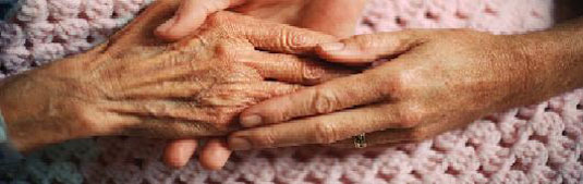 enfermera acariciando la mano de una anciana