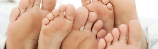 foto de una familia en la cama con los pies enseandolos